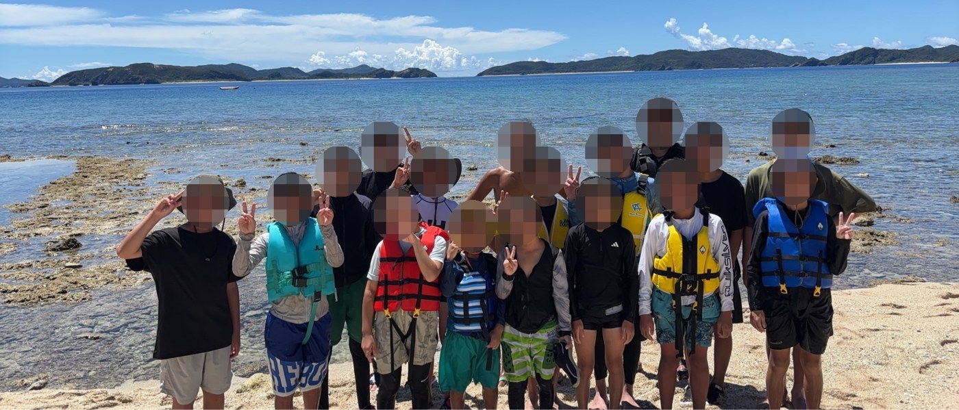 沖縄の海辺で撮った引率時の集合写真（顔はモザイク加工）